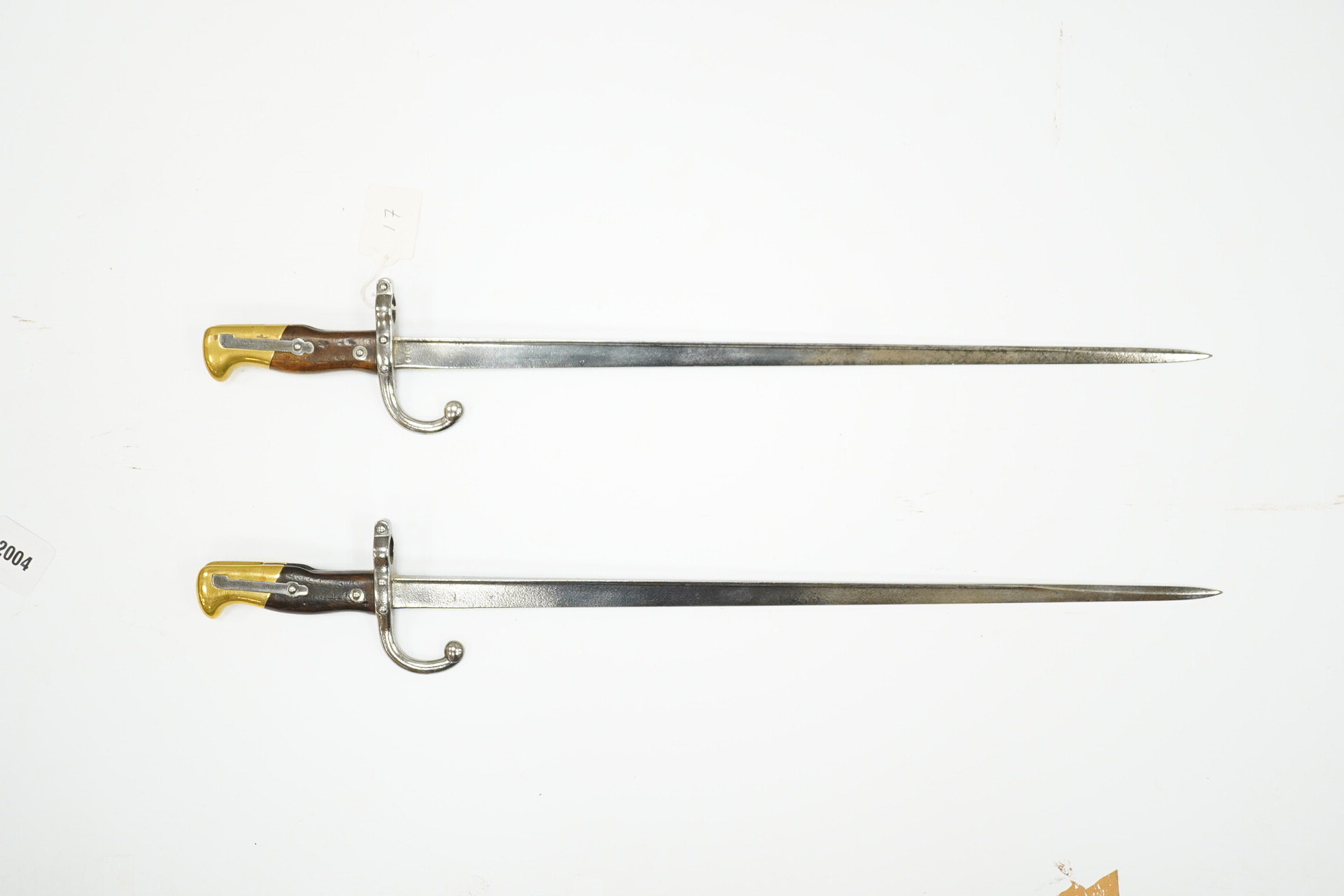 Two French Gras bayonets; a bayonet with a T-section blade dated 1877, and another almost identical blade dated 1879, scabbards missing. Condition - good